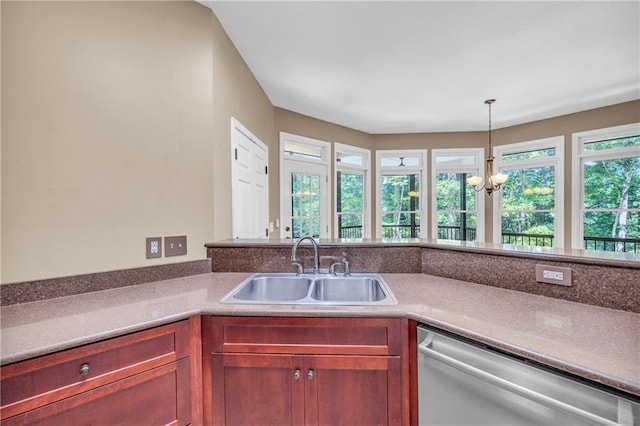 kitchen featuring stainless steel dishwasher, a sink, plenty of natural light, and a chandelier