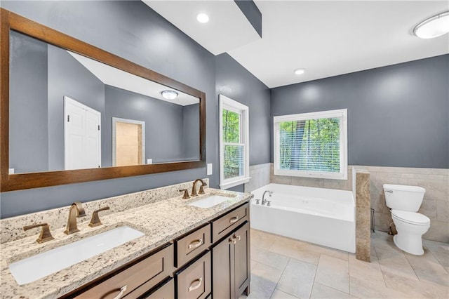 full bath featuring a sink, double vanity, toilet, and a bath