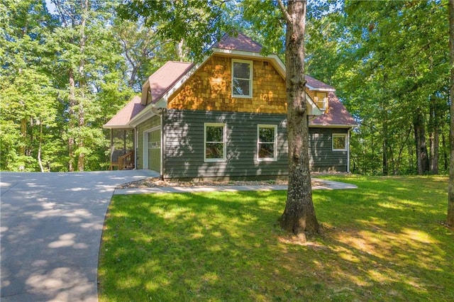 view of front of house featuring an attached garage, driveway, and a front lawn