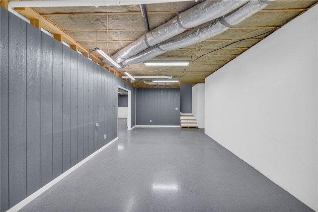 unfinished basement with stairs and wood walls
