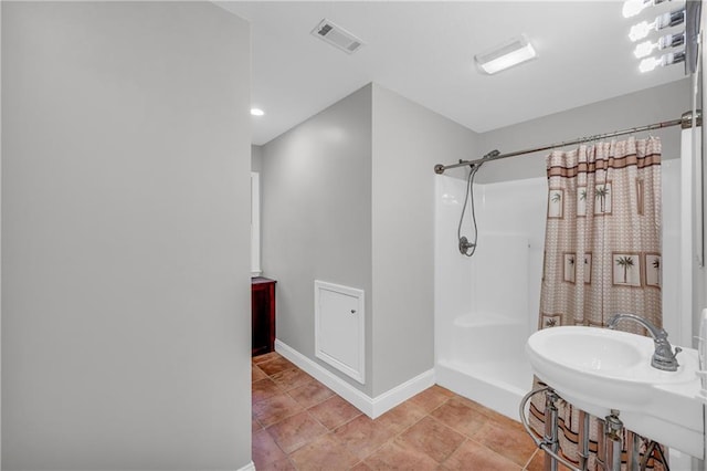 bathroom featuring a sink, a shower with curtain, visible vents, and baseboards
