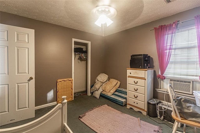 carpeted bedroom with a textured ceiling, ceiling fan, and a closet