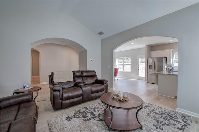 living room with light hardwood / wood-style flooring and high vaulted ceiling