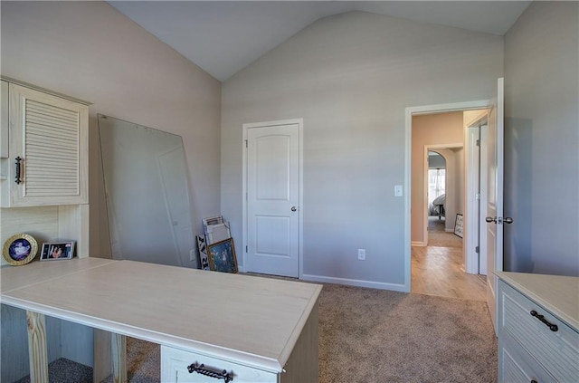 office space with lofted ceiling and light carpet