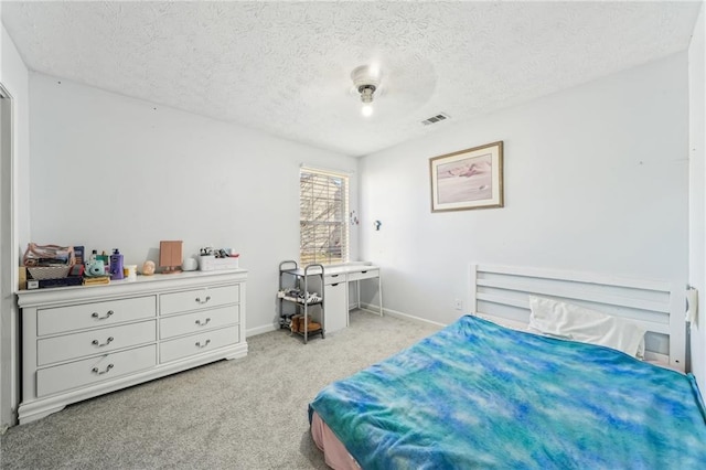 bedroom featuring carpet, visible vents, a textured ceiling, and baseboards