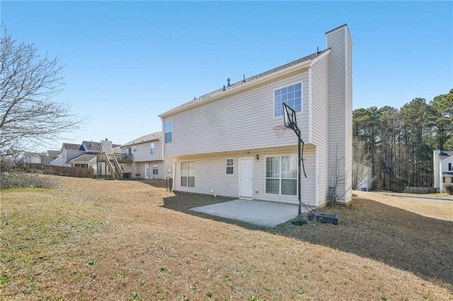 rear view of property with a patio, a chimney, and a lawn