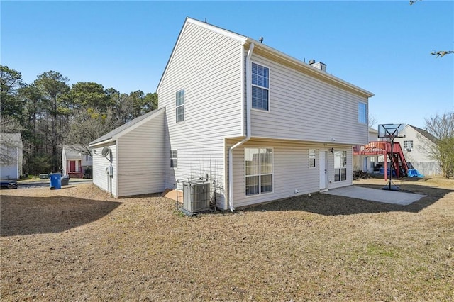 rear view of property featuring a patio area, a yard, and central AC unit