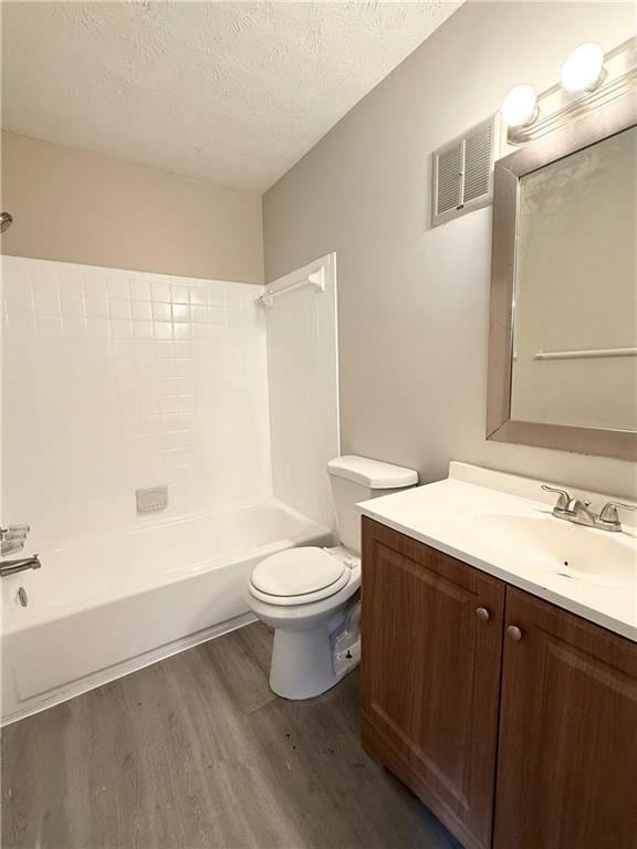 296 Country Club Dr, Jonesboro, GA 30238 - full bath featuring wood finished floors, vanity, toilet, bathtub / shower combination, and a textured ceiling