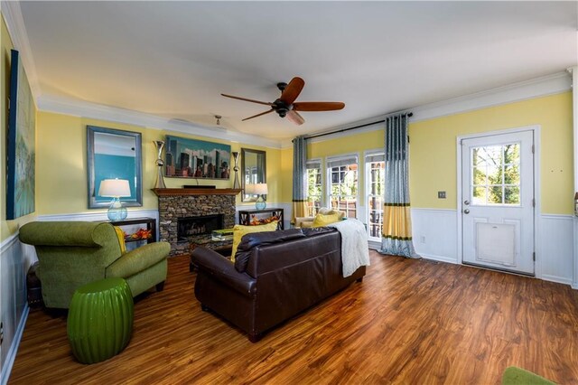 living room with ceiling fan, a fireplace, dark wood-type flooring, and ornamental molding