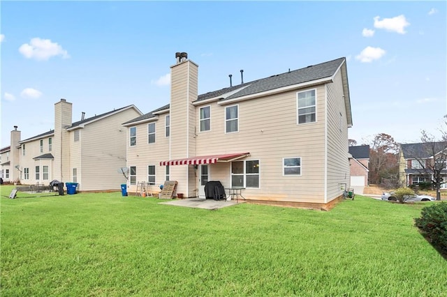 back of house with a lawn and a patio