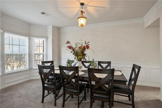 dining area with carpet and ornamental molding