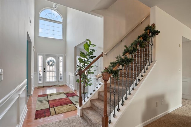 entryway with carpet floors and a high ceiling