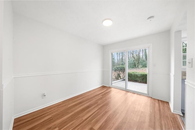 spare room featuring wood-type flooring and plenty of natural light