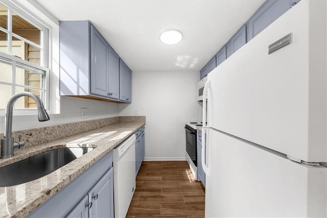 kitchen featuring dark hardwood / wood-style flooring, sink, light stone counters, and white appliances