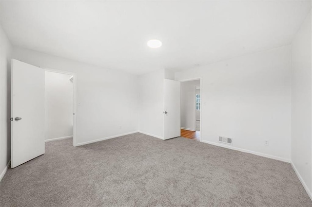 unfurnished room featuring light carpet