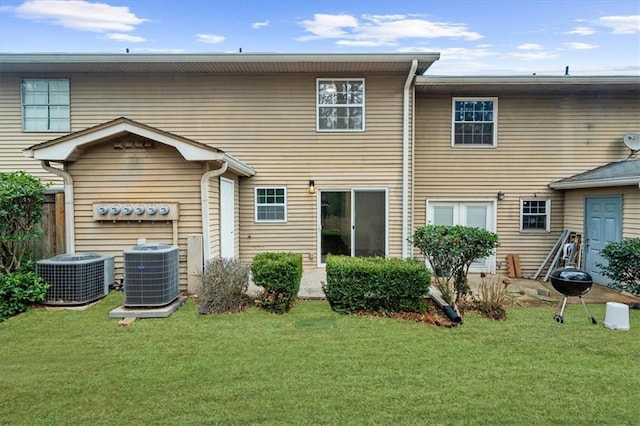 back of house with a yard and central AC