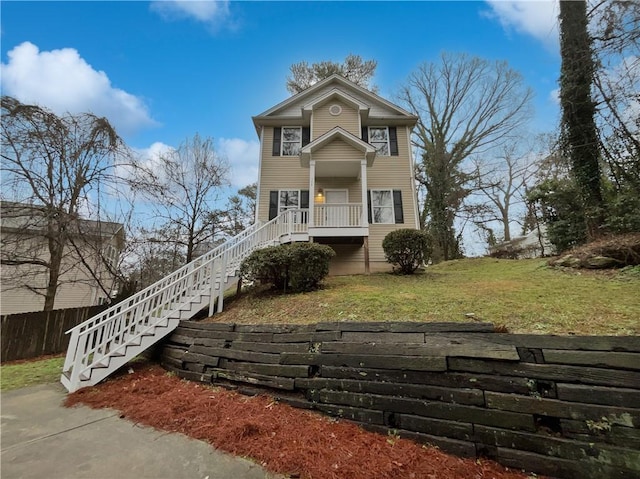 view of front of property featuring a front lawn, stairs, and fence