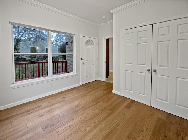 entrance foyer featuring wood finished floors, baseboards, and ornamental molding