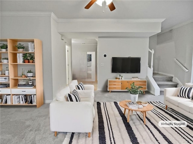 carpeted living room with ceiling fan, ornamental molding, and stairs