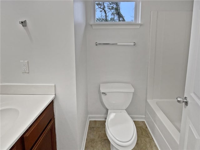 full bathroom with vanity, toilet, a tub to relax in, and baseboards