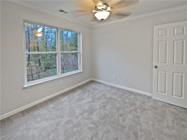 empty room featuring visible vents, baseboards, carpet, ornamental molding, and a ceiling fan