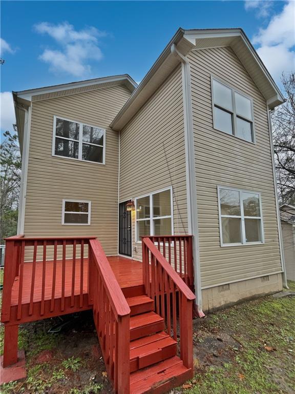 rear view of property with crawl space and a wooden deck