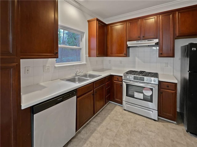 kitchen featuring stainless steel range with gas cooktop, under cabinet range hood, dishwasher, freestanding refrigerator, and a sink