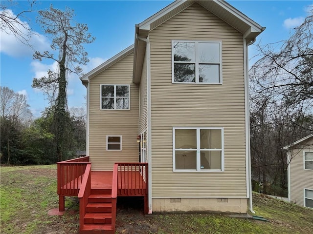 rear view of property with crawl space, a lawn, and a wooden deck