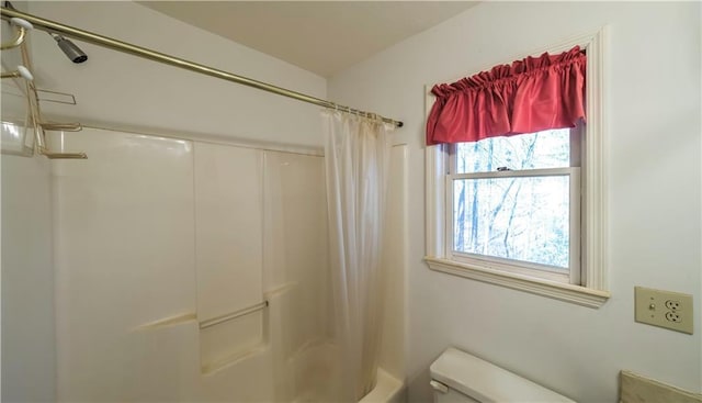 bathroom featuring shower / tub combo with curtain and toilet