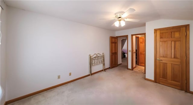 unfurnished bedroom with a ceiling fan, light carpet, and baseboards