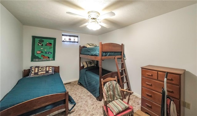 carpeted bedroom with ceiling fan and baseboards