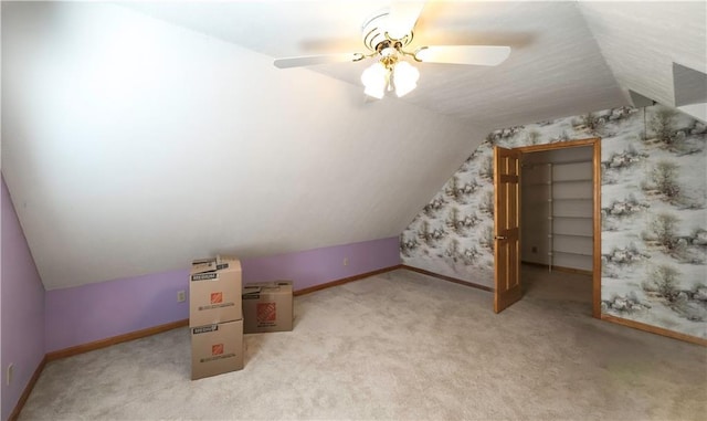 additional living space featuring a ceiling fan, lofted ceiling, light carpet, and baseboards