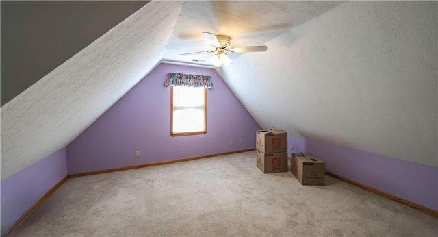 bonus room featuring a textured ceiling, ceiling fan, lofted ceiling, and baseboards