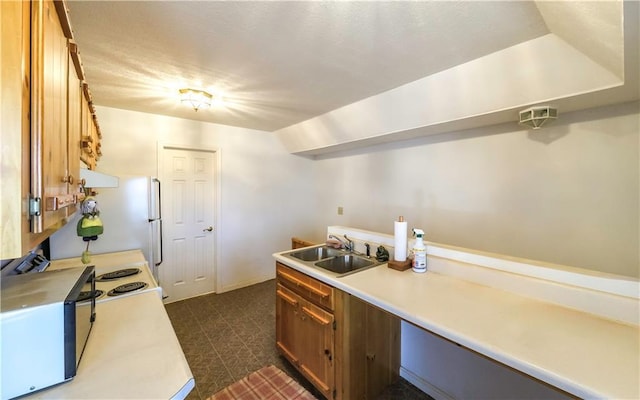 kitchen with light countertops, a sink, and brown cabinets