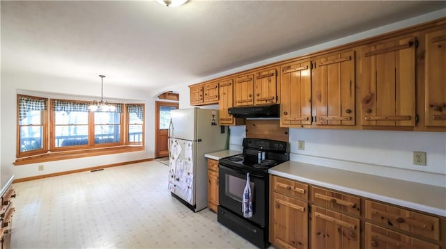 kitchen with brown cabinets, light countertops, black electric range oven, freestanding refrigerator, and under cabinet range hood