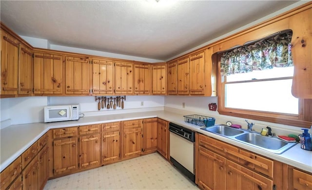 kitchen featuring white appliances, light floors, a sink, and light countertops