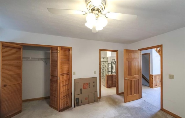 unfurnished bedroom with ceiling fan, carpet floors, a closet, and baseboards