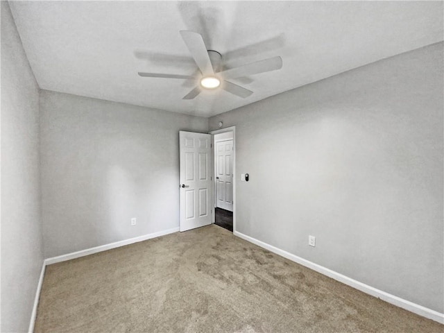 unfurnished room with ceiling fan and carpet