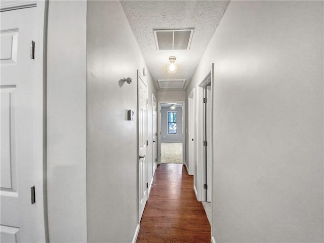 hallway featuring dark hardwood / wood-style flooring and a textured ceiling