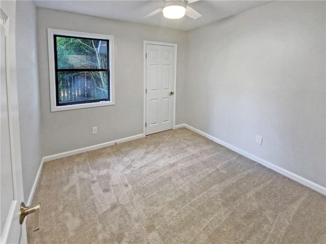 spare room featuring ceiling fan and light colored carpet