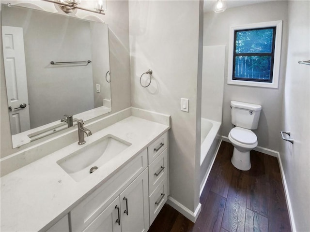 bathroom with toilet, vanity, and hardwood / wood-style flooring