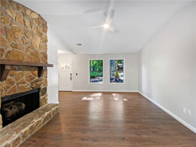 unfurnished living room featuring a stone fireplace, ceiling fan, dark wood-type flooring, and lofted ceiling