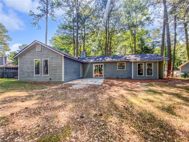 back of house featuring a lawn and a patio area