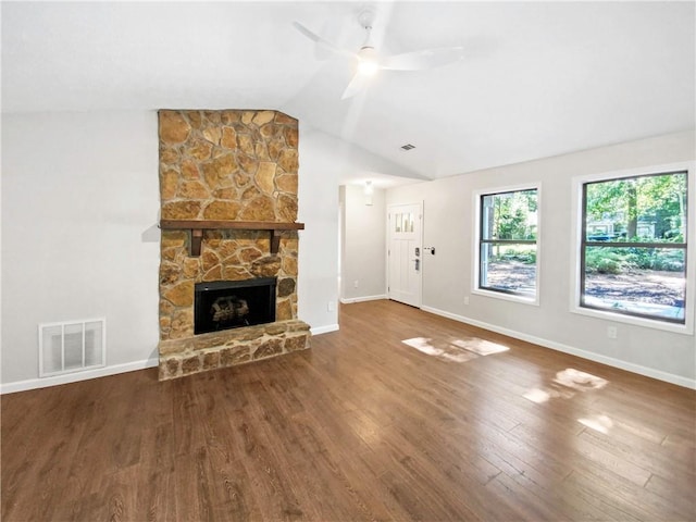 unfurnished living room with ceiling fan, a stone fireplace, wood-type flooring, and vaulted ceiling