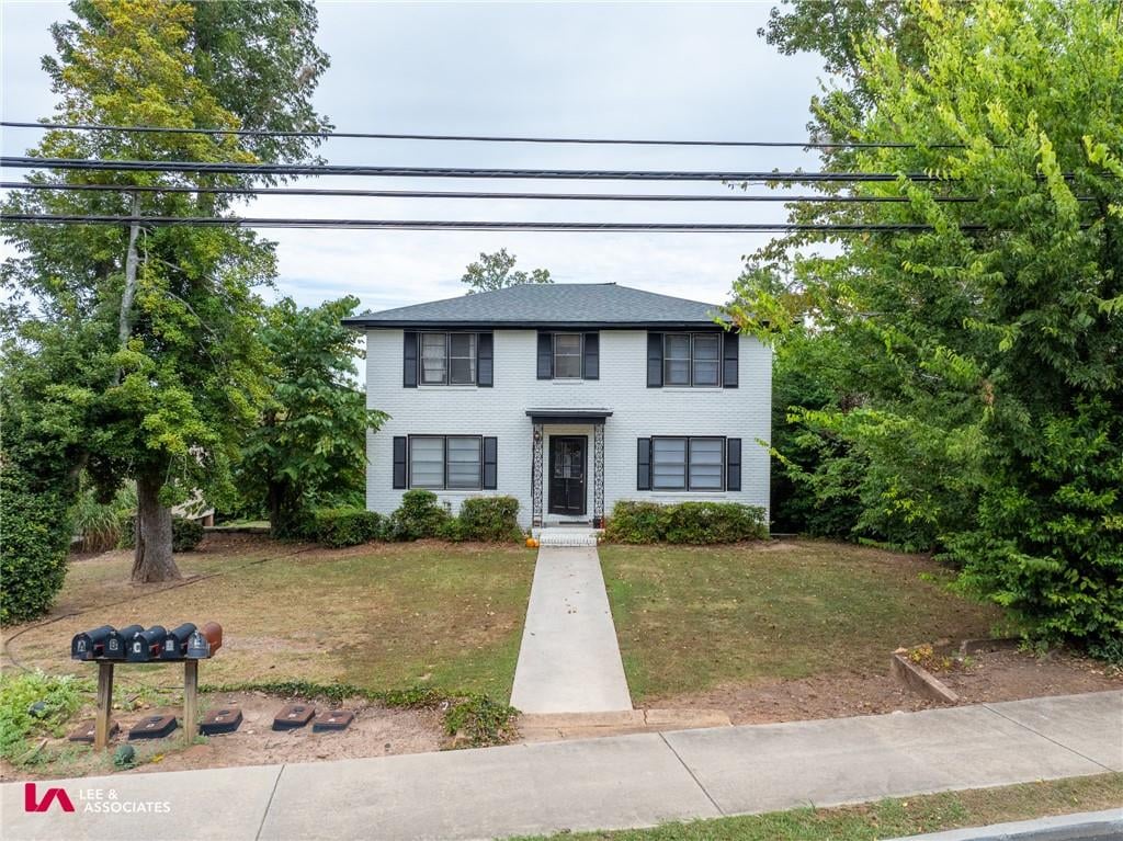 colonial inspired home with a front lawn