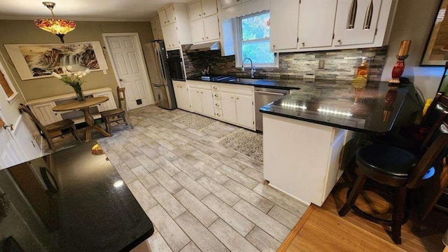 2479 Landeau Cir, Tucker, GA 30084 - kitchen featuring stainless steel dishwasher, a sink, white cabinetry, dark countertops, and a peninsula