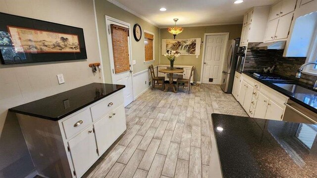 2479 Landeau Cir, Tucker, GA 30084 - kitchen with a sink, crown molding, white cabinets, light wood finished floors, and freestanding refrigerator