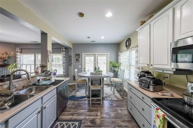 7835 Keepsake Ln, Flowery Branch, GA 30542 - kitchen featuring stainless steel appliances, a sink, dark wood-style floors, white cabinetry, and light countertops
