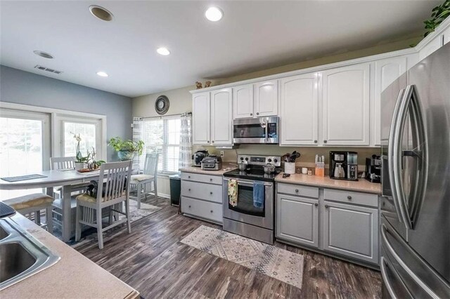 7835 Keepsake Ln, Flowery Branch, GA 30542 - kitchen with stainless steel appliances, light countertops, dark wood-style flooring, white cabinetry, and recessed lighting