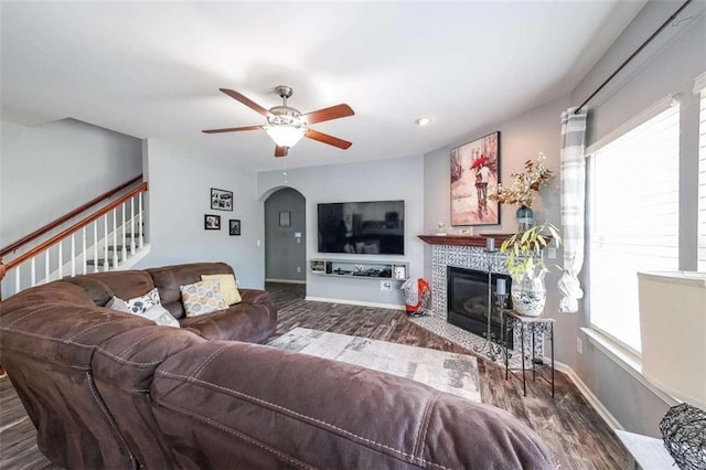 7835 Keepsake Ln, Flowery Branch, GA 30542 - living room with arched walkways, healthy amount of natural light, a ceiling fan, and a fireplace